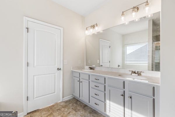 1494 Weeping Tree Cir, Hoschton, GA 30548 - bathroom with double vanity and a shower with door