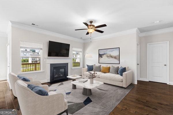1494 Weeping Tree Cir, Hoschton, GA 30548 - living area featuring wood finished floors, a ceiling fan, crown molding, and a glass covered fireplace