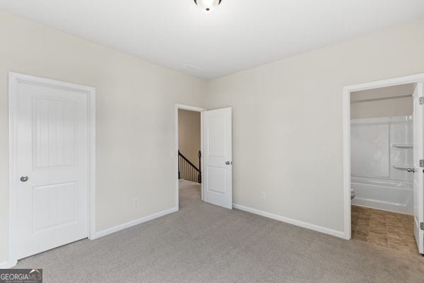 1494 Weeping Tree Cir, Hoschton, GA 30548 - unfurnished bedroom with carpet floors and a closet