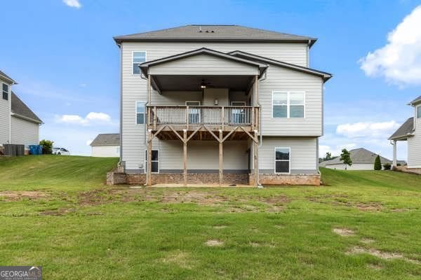 1494 Weeping Tree Cir, Hoschton, GA 30548 - rear view of property featuring a lawn and a wooden deck