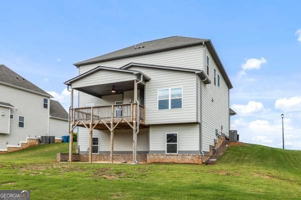 1494 Weeping Tree Cir, Hoschton, GA 30548 - back of house with a balcony and a lawn