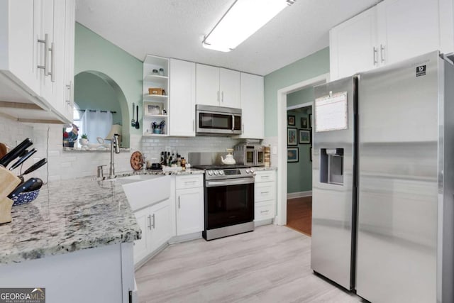 3820 Pheasant Run Trce, Cumming, GA 30028 - kitchen featuring stainless steel appliances, white cabinets, tasteful backsplash, light stone counters, and open shelves