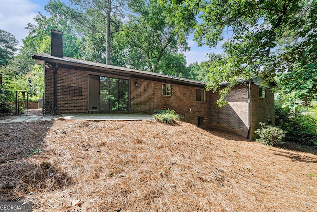1260 Fork Creek Trl, Decatur, GA 30033 - back of property featuring brick siding, a chimney, and a patio area