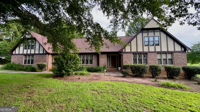 186 Kingston Rd, Colbert, GA 30628 - tudor house with brick siding, a front yard, and a chimney