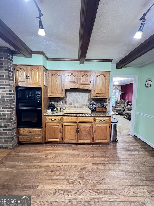 186 Kingston Rd, Colbert, GA 30628 - kitchen featuring beamed ceiling, light wood-style flooring, a textured ceiling, black appliances, and tasteful backsplash