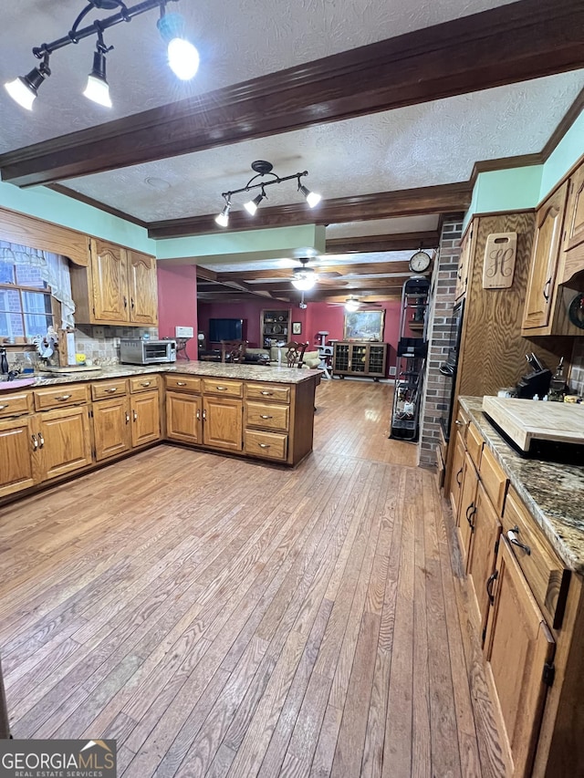 186 Kingston Rd, Colbert, GA 30628 - kitchen with a peninsula, light wood-type flooring, rail lighting, open floor plan, and brown cabinetry