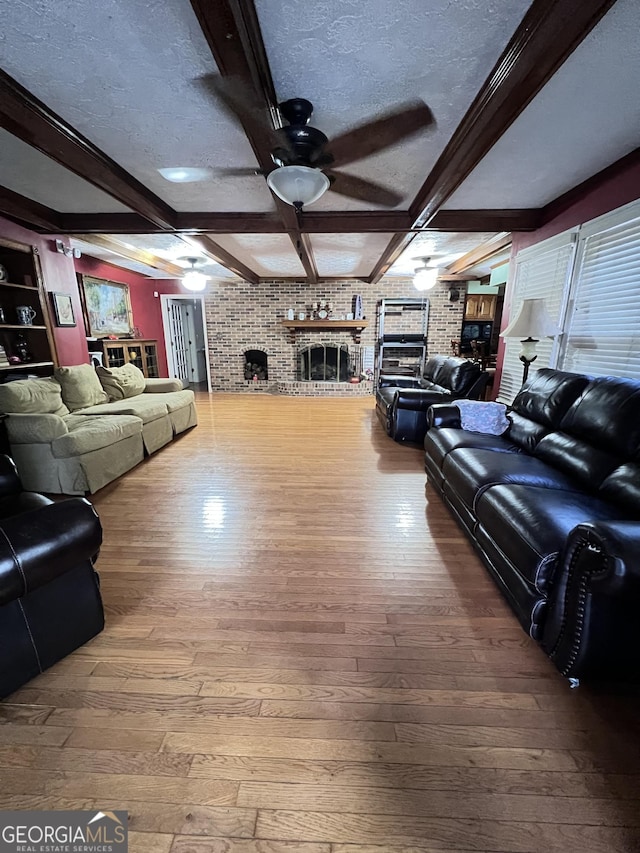 186 Kingston Rd, Colbert, GA 30628 - living room featuring a fireplace, ceiling fan, hardwood / wood-style flooring, beam ceiling, and a textured ceiling