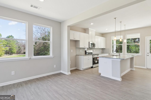 105 Ivy Glen Dr, Perry, GA 31069 - kitchen featuring stainless steel appliances, light wood finished floors, light stone counters, decorative backsplash, and white cabinetry