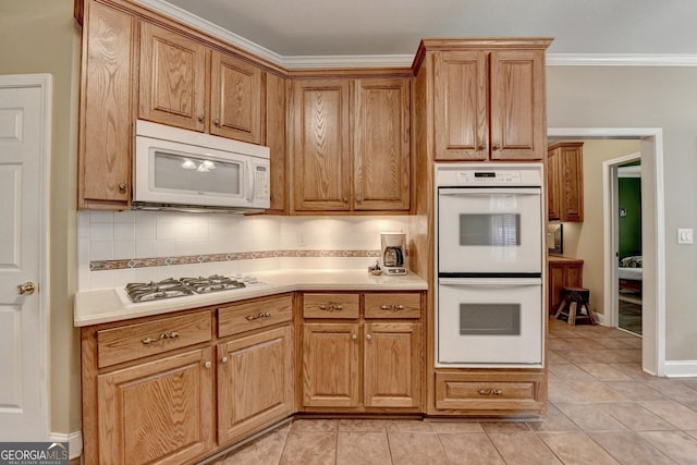 1640 Mount Mckinley Dr, Grayson, GA 30017 - kitchen with white appliances, light countertops, backsplash, light tile patterned floors, and crown molding