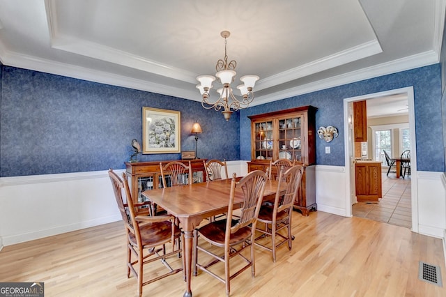 1640 Mount Mckinley Dr, Grayson, GA 30017 - dining space featuring a raised ceiling, a chandelier, light wood-style floors, wainscoting, and crown molding