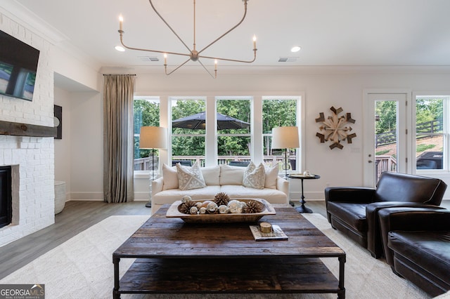 15755 Burdette Ct, Milton, GA 30004 - living room with a chandelier, light wood-style floors, a brick fireplace, ornamental molding, and recessed lighting