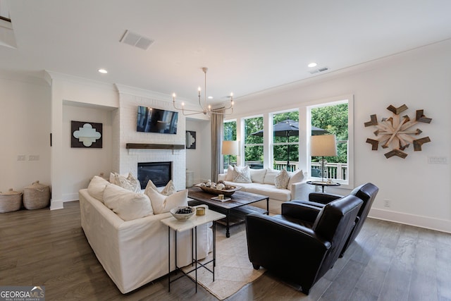 15755 Burdette Ct, Milton, GA 30004 - living room featuring a chandelier, ornamental molding, a fireplace, wood finished floors, and recessed lighting