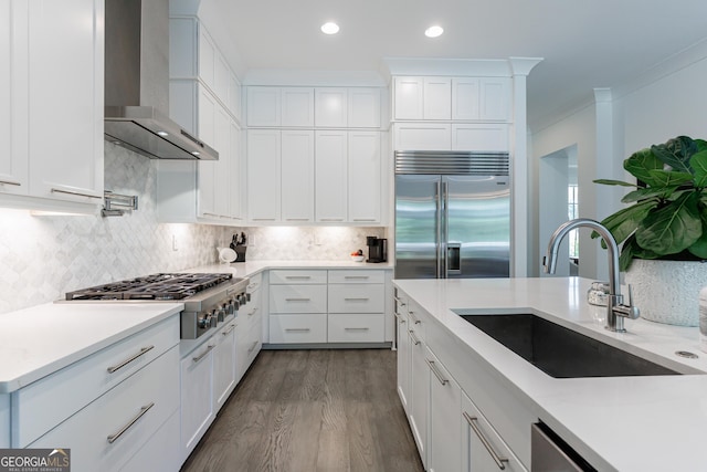 15755 Burdette Ct, Milton, GA 30004 - kitchen with appliances with stainless steel finishes, wall chimney exhaust hood, dark wood-style floors, white cabinets, and decorative backsplash