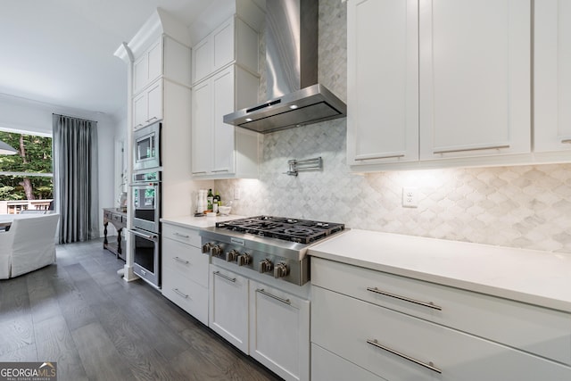 15755 Burdette Ct, Milton, GA 30004 - kitchen featuring wall chimney range hood, appliances with stainless steel finishes, dark wood-style floors, white cabinetry, and light countertops