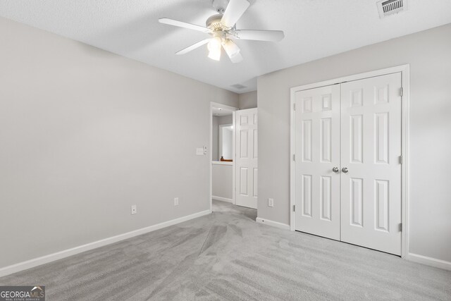 8750 Redford Ln, Suwanee, GA 30024 - unfurnished bedroom with light carpet, a closet, and a ceiling fan
