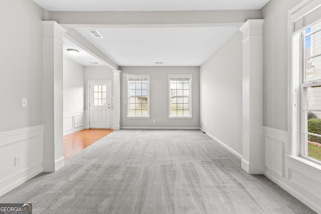 8750 Redford Ln, Suwanee, GA 30024 - carpeted empty room featuring decorative columns, wainscoting, and a decorative wall