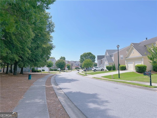 8750 Redford Ln, Suwanee, GA 30024 - view of asphalt road featuring sidewalks, a residential view, street lighting, and curbs