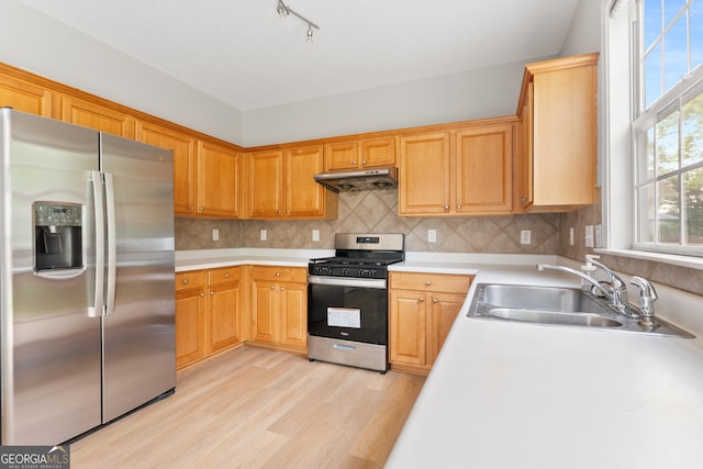 8750 Redford Ln, Suwanee, GA 30024 - kitchen featuring stainless steel appliances, under cabinet range hood, light countertops, light wood-style floors, and backsplash