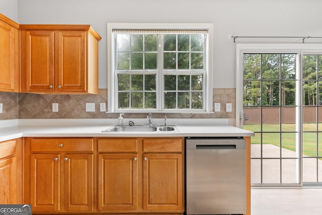 8750 Redford Ln, Suwanee, GA 30024 - kitchen featuring stainless steel dishwasher, light countertops, backsplash, and brown cabinets