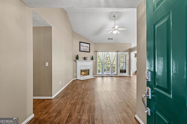 5832 Sycamore Ridge Dr, Sugar Hill, GA 30518 - entrance foyer with wood finished floors, ceiling fan, vaulted ceiling, a glass covered fireplace, and a textured ceiling