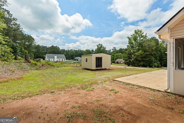501 Llewellyn Ct, Jenkinsburg, GA 30234 - view of green lawn featuring a storage unit, a patio area, and view of scattered trees