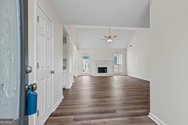 501 Llewellyn Ct, Jenkinsburg, GA 30234 - unfurnished living room featuring ceiling fan, dark wood-type flooring, vaulted ceiling, and a fireplace with raised hearth