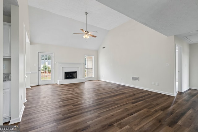 501 Llewellyn Ct, Jenkinsburg, GA 30234 - unfurnished living room with ceiling fan, attic access, dark wood-style flooring, a fireplace with raised hearth, and high vaulted ceiling