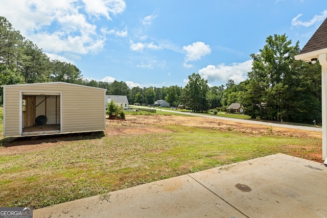 501 Llewellyn Ct, Jenkinsburg, GA 30234 - view of grassy yard with view of wooded area, a storage unit, and a patio