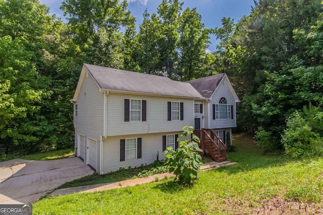 1404 Lancaster Ct, Mcdonough, GA 30252 - split foyer home featuring stairway, driveway, an attached garage, and a front yard
