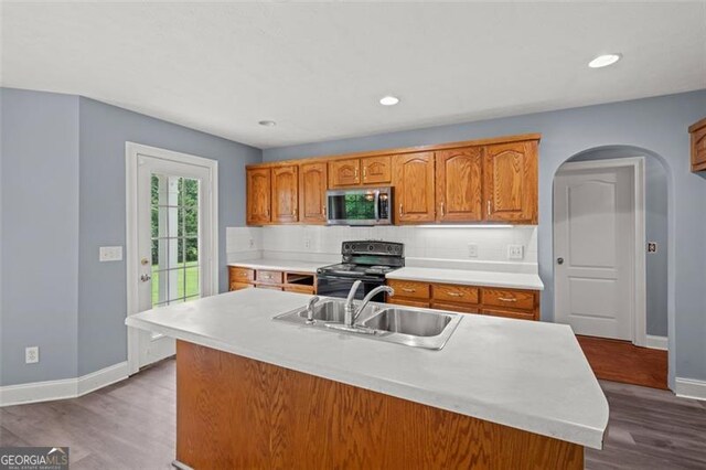 2333 Old Newnan Rd, Carrollton, GA 30116 - kitchen featuring stainless steel microwave, black electric range oven, light countertops, brown cabinets, and tasteful backsplash