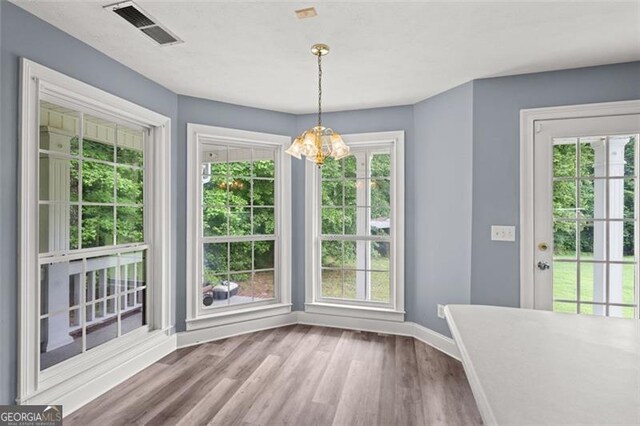 2333 Old Newnan Rd, Carrollton, GA 30116 - unfurnished dining area with plenty of natural light, wood finished floors, and a chandelier