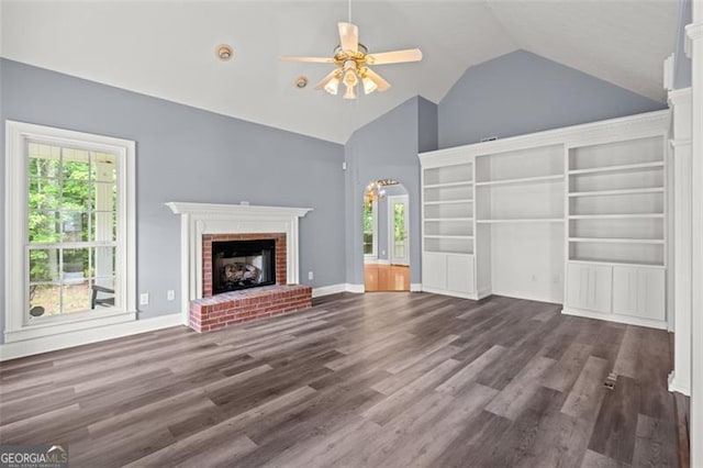 2333 Old Newnan Rd, Carrollton, GA 30116 - unfurnished living room featuring ceiling fan, a fireplace, wood finished floors, high vaulted ceiling, and arched walkways