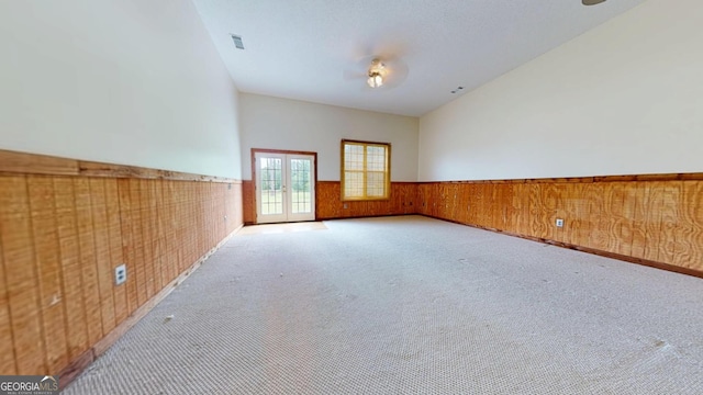 26 Ben Blvd, Swainsboro, GA 30401 - empty room featuring a wainscoted wall, french doors, carpet, and wooden walls