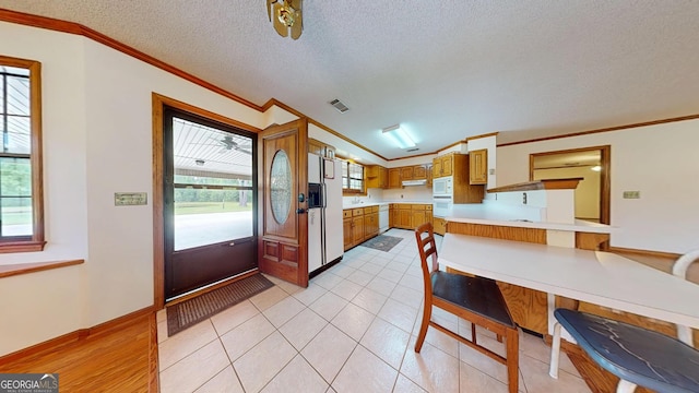 26 Ben Blvd, Swainsboro, GA 30401 - kitchen with white appliances, ornamental molding, a peninsula, light countertops, and a textured ceiling