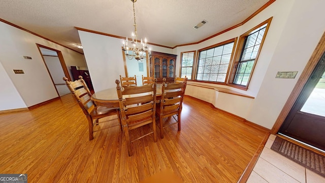 26 Ben Blvd, Swainsboro, GA 30401 - dining room featuring crown molding, light wood-style flooring, a chandelier, and a textured ceiling