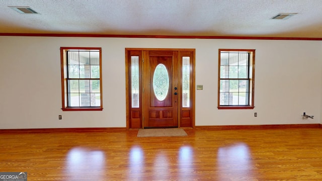 26 Ben Blvd, Swainsboro, GA 30401 - entrance foyer with plenty of natural light, a textured ceiling, wood finished floors, and crown molding