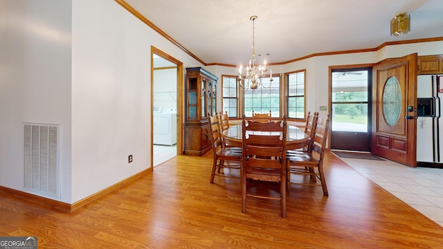 26 Ben Blvd, Swainsboro, GA 30401 - dining area featuring a chandelier, washer / dryer, ornamental molding, and light wood-style flooring