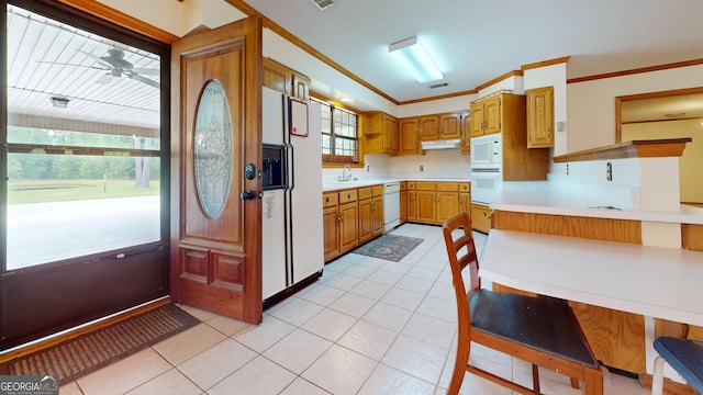 26 Ben Blvd, Swainsboro, GA 30401 - kitchen featuring white appliances, under cabinet range hood, light countertops, light tile patterned floors, and brown cabinets