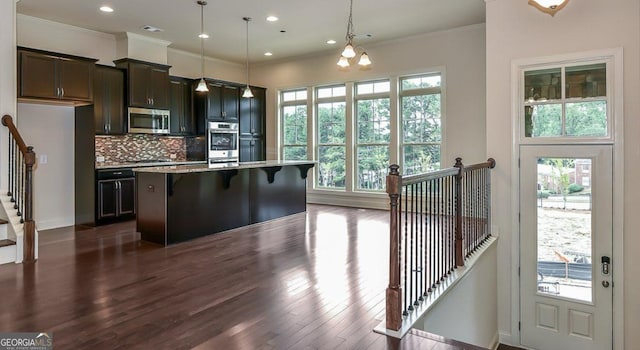1306 Harris Way, Brookhaven, GA 30319 - kitchen featuring appliances with stainless steel finishes, a breakfast bar area, dark wood-type flooring, a kitchen island, and healthy amount of natural light