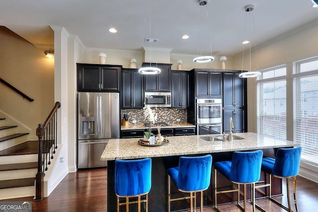 1306 Harris Way, Brookhaven, GA 30319 - kitchen featuring appliances with stainless steel finishes, a large island, tasteful backsplash, a kitchen bar, and dark wood finished floors