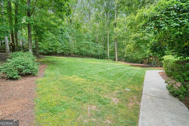 627 Apache Trl, Woodstock, GA 30189 - view of green lawn featuring a forest view