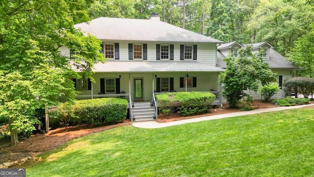 627 Apache Trl, Woodstock, GA 30189 - colonial house featuring covered porch, a chimney, a front lawn, and a shingled roof