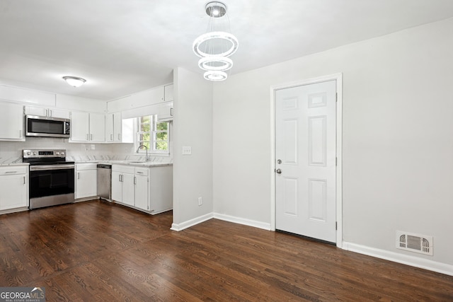 3611 Radcliffe Blvd, Decatur, GA 30034 - kitchen featuring appliances with stainless steel finishes, light countertops, dark wood finished floors, a chandelier, and white cabinets