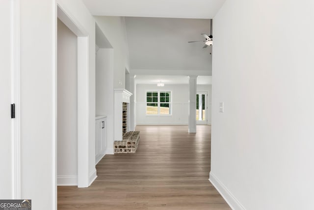 797 Ode Peppers Rd, Winder, GA 30680 - hallway featuring light wood-type flooring, decorative columns, and a towering ceiling