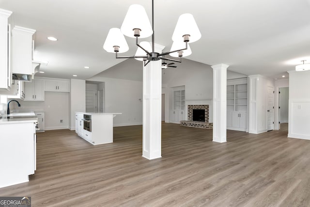 797 Ode Peppers Rd, Winder, GA 30680 - unfurnished living room with a chandelier, recessed lighting, a brick fireplace, light wood-type flooring, and lofted ceiling