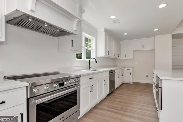 797 Ode Peppers Rd, Winder, GA 30680 - kitchen with appliances with stainless steel finishes, custom range hood, light countertops, white cabinets, and recessed lighting