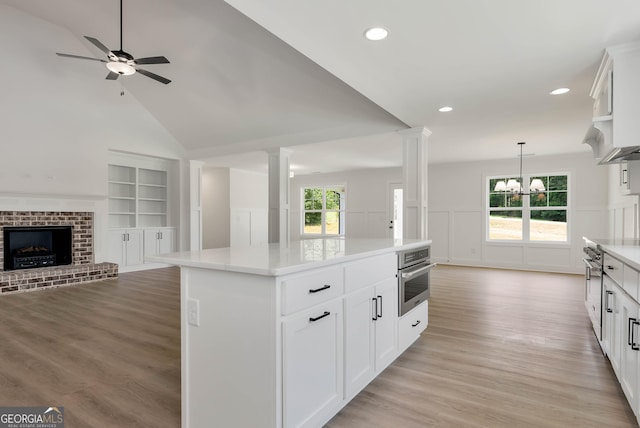 797 Ode Peppers Rd, Winder, GA 30680 - kitchen featuring open floor plan, oven, ornate columns, light countertops, and light wood-style floors