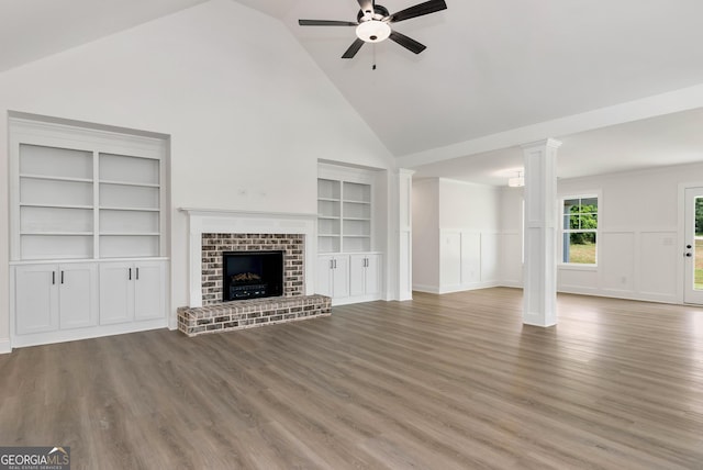 797 Ode Peppers Rd, Winder, GA 30680 - unfurnished living room featuring high vaulted ceiling, ceiling fan, wood finished floors, a fireplace, and ornate columns