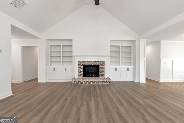 797 Ode Peppers Rd, Winder, GA 30680 - unfurnished living room featuring high vaulted ceiling, built in features, a brick fireplace, wood finished floors, and ceiling fan