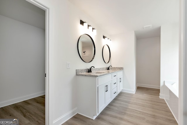797 Ode Peppers Rd, Winder, GA 30680 - bathroom featuring double vanity, wood finished floors, and a garden tub